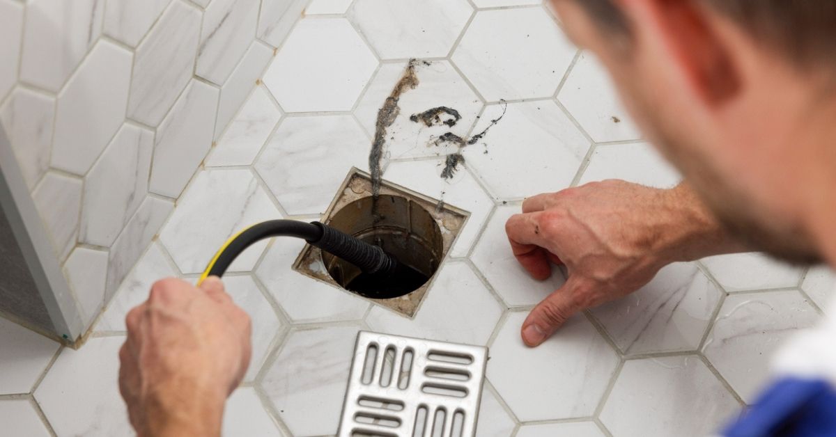 man clearing sink drain
